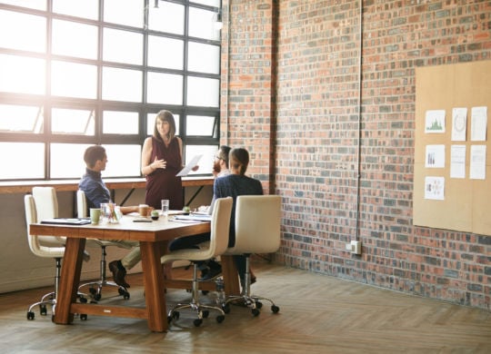 Shot of a pregnant businesswoman having a discussion with her team in a modern office